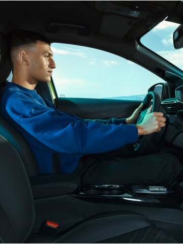 Man driving the PEUGEOT E-208